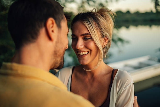istock Young couple sharing a romantic moment by the lake 2205533846