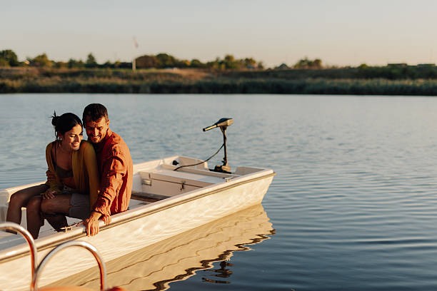istock Young couple relaxing on a boat at sunset 2205533999