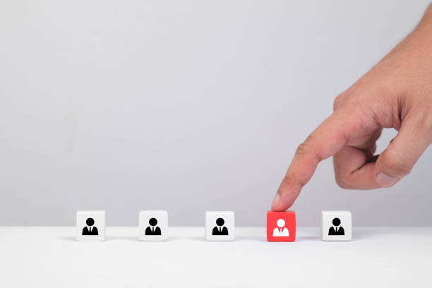 istock A hand selecting an individual icon from a line of figures, symbolizing choice, selection, or importance in teamwork or recruitment. 2205534970