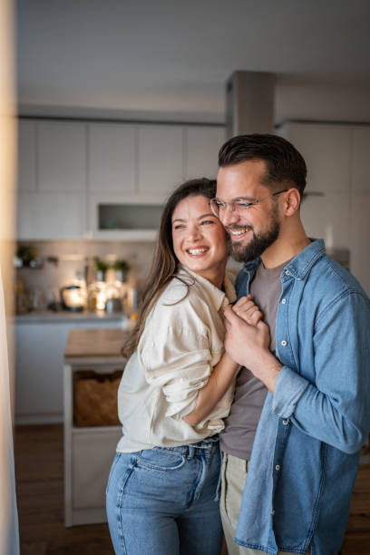 istock Happy young couple embracing tenderly in their modern kitchen 2205539763