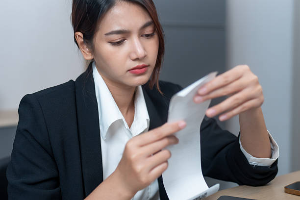 istock woman in black suit examines receipt with focused expression, showcasing professionalism and attention to detail in office setting 2205540847