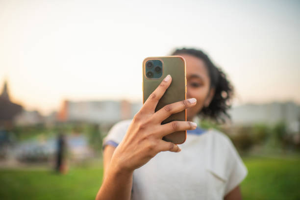 istock Young woman with smartphone outdoors in summer 2205541101