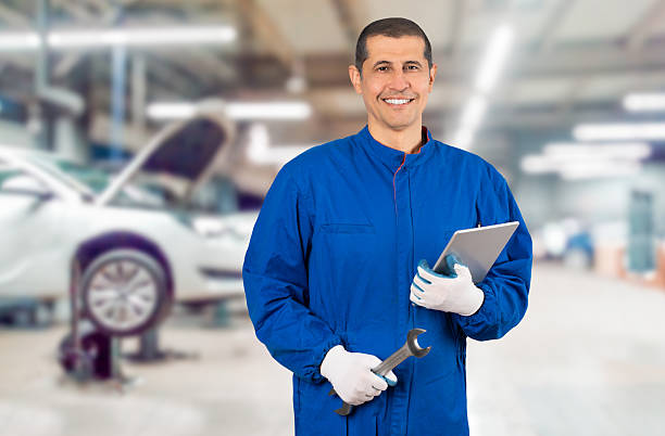 Smiling repairman holding wrench at the workshop