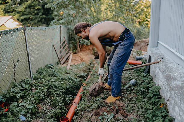 plumber repairing a sewer pipe in the yard