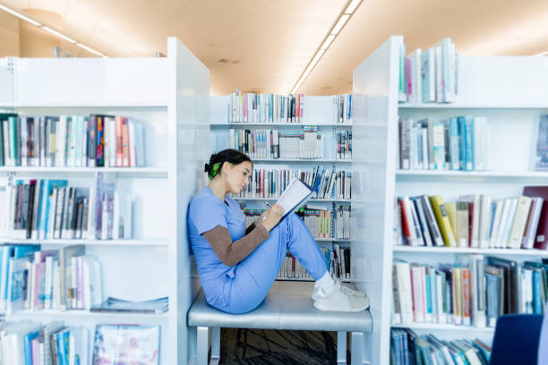 istock Focused Female Student Studying in Library Nook 2205543780