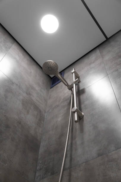 istock Modern shower head hanging elegantly in a contemporary bathroom, highlighting its sleek design and functionality against a stylish backdrop of gray tiles, enhancing the space's luxury and comfort 2205544229