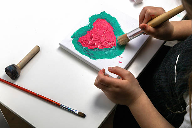 istock The child paints a red heart 2205544249