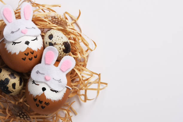 istock Hand painted eggs sleeping owls in sleep masks in a nest with quail eggs. Space for your text. 2205544488