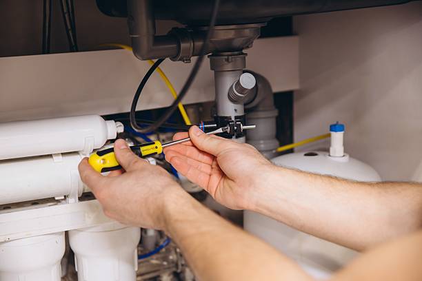 istock Plumber tightening a screw under the kitchen sink using a screwdriver 2205544491
