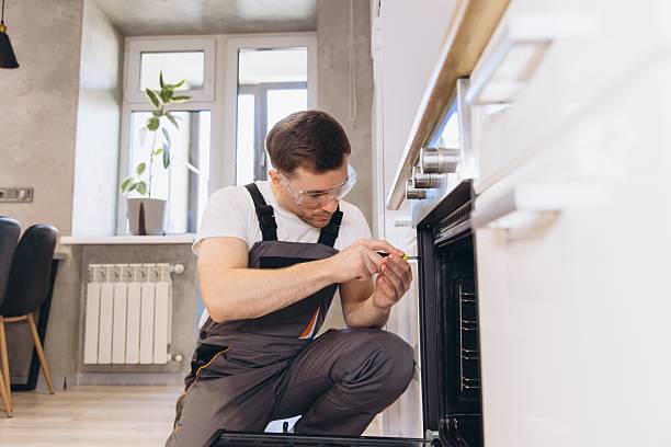 istock Plumber Repairing Oven in Modern Kitchen 2205544651