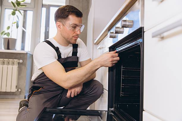 istock Professional plumber repairing oven in a modern kitchen 2205544681