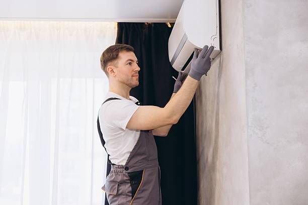 professional handyman installing or repairing modern air conditioner unit - klima stok fotoğraflar ve resimler