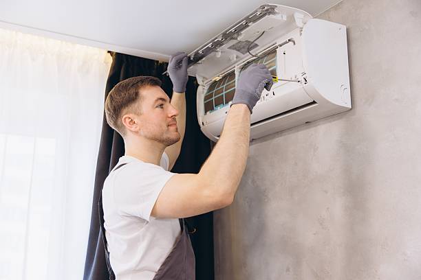 istock Plumber Repairing Air Conditioner Unit with Screwdriver 2205544791