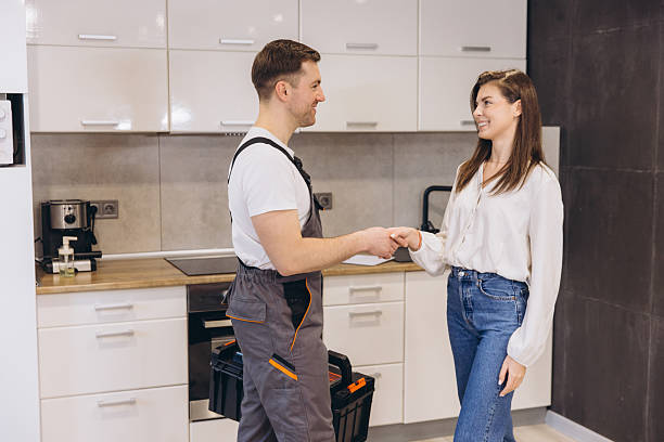 istock Plumber shaking hands with woman after finishing work in kitchen 2205544984