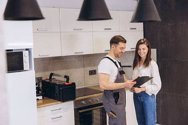 istock Plumber showing repair cost estimate to customer in kitchen 2205544998