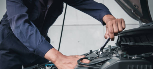istock Mechanic using wrench while working on car engine outside the service center , Repair and service. 2205545244