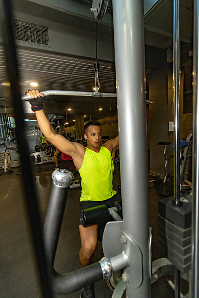 Focused Male Athlete Gripping Pull-Up Bar in Modern Gym