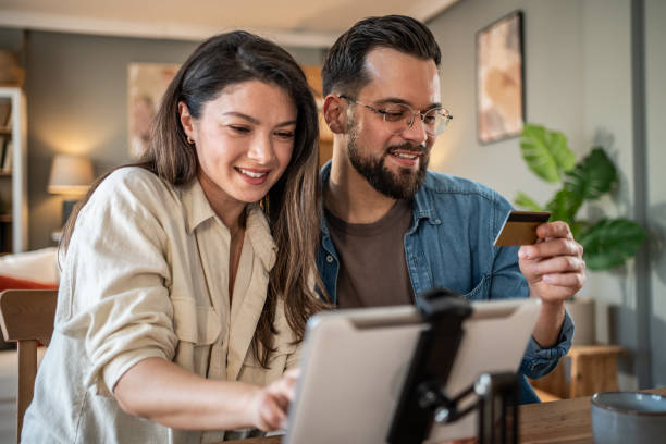 istock Happy couple making online payment using digital tablet and credit card at home 2205547069