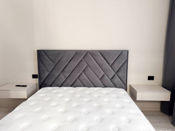 istock a modern bedroom with a minimalist design, featuring a gray upholstered headboard with a geometric pattern 2205548437