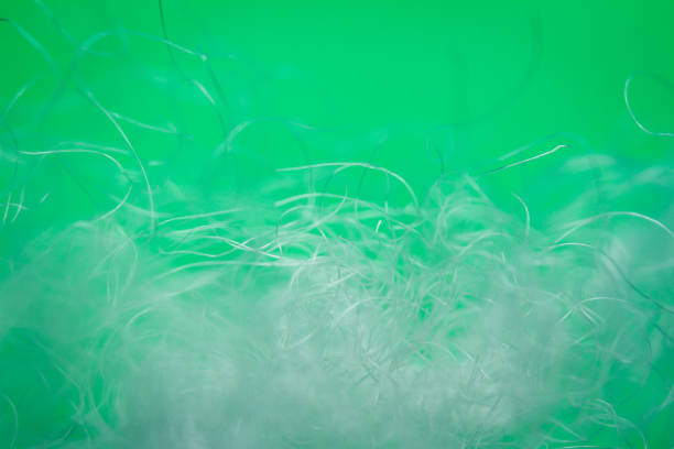 Extreme macro of polyester stable fiber on green background. Selective focus, shallow depth of field. Abstract dreamy background