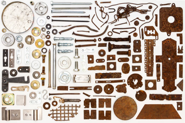 A group of various old and new parts arranged on white. Old rusty nuts, bolts, nails and other parts flay lay on white background.