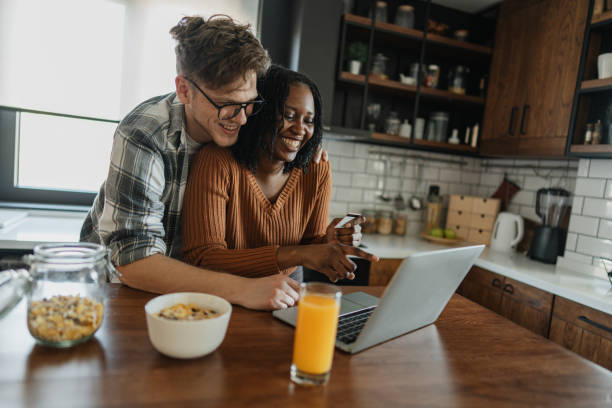 istock Couple Celebrating with Laughter and Technology 2205551376