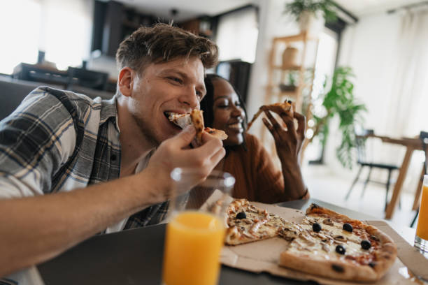 istock Joyful friends enjoying delicious pizza together 2205552331