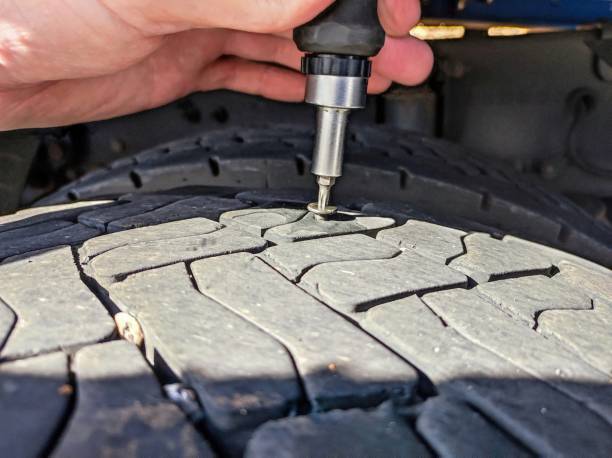 istock man pumping up a flat tire on a truck 2205554556
