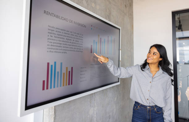 istock Businesswoman pointing at a graph on a screen while making a presentation at the office 2205555658