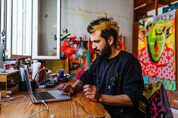 istock Contemporary artist working in his painting studio. 2205557196