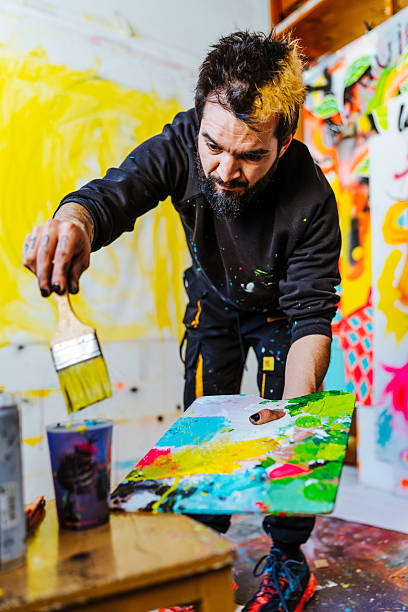 istock Artist Mixing Paint on a Palette in His Creative Studio 2205557241