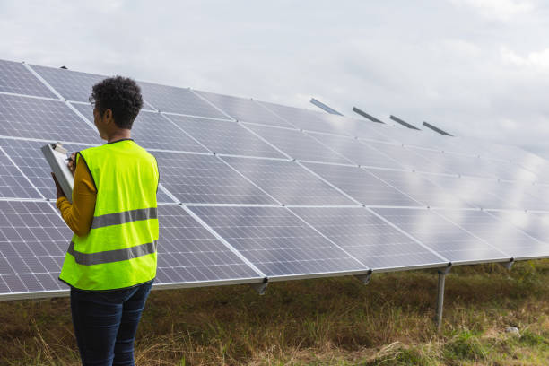 istock Technician Inspecting Solar Panels at Renewable Energy Farm 2205558751