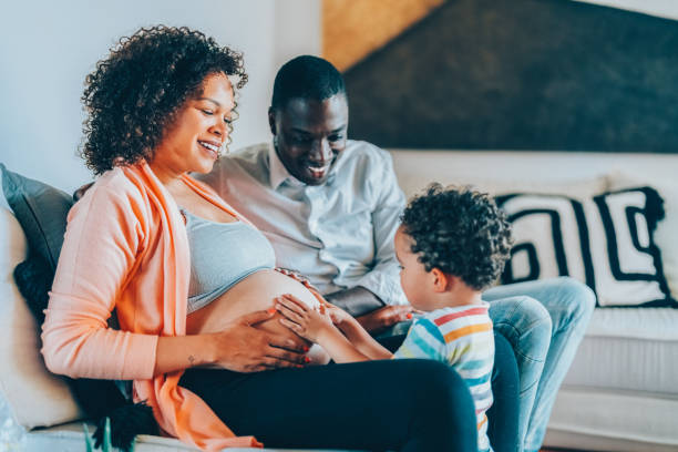 istock Boy with hands on mother’s belly feeling the baby’s movements and kicks 2205558921