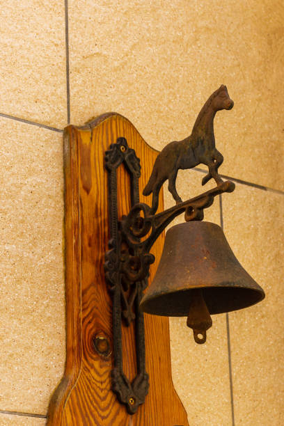 istock Rustic Wall-Mounted Bell With Decorative Horse on Wooden Backboard 2205559209