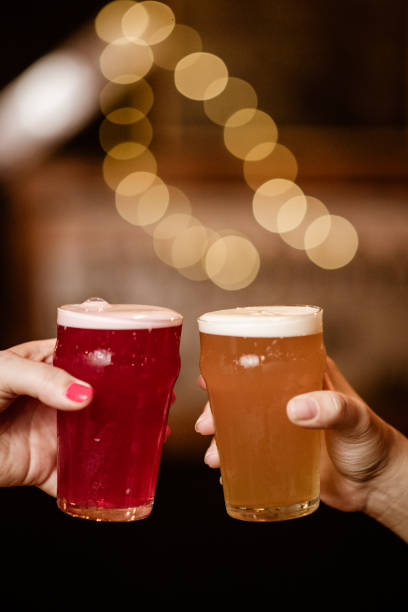 istock Two hands hold pint glasses in celebratory gesture 2205559384