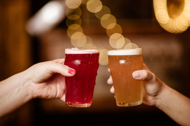 istock Two hands hold pint glasses in celebratory gesture 2205559397