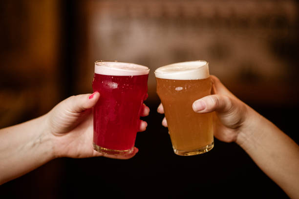 istock Two hands hold pint glasses in celebratory gesture 2205559409