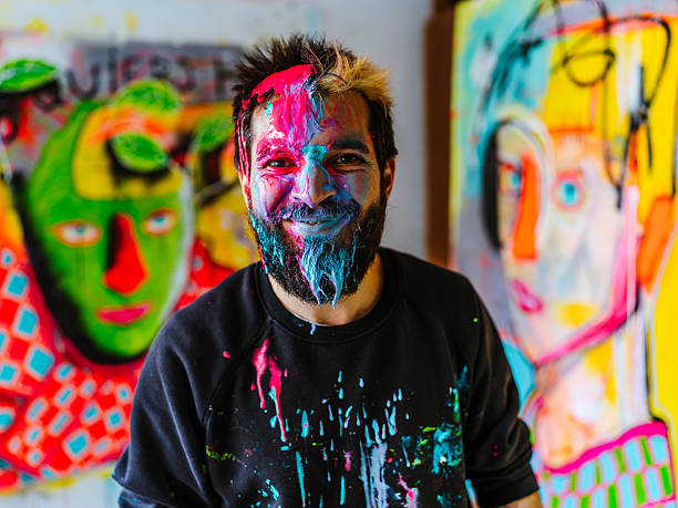 istock Smiling Artist with Face Covered in Vibrant Paint. 2205559440