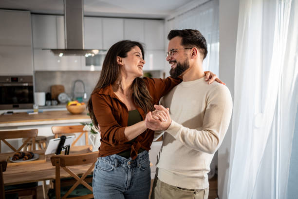 istock Happy couple dancing together in their modern kitchen 2205559576