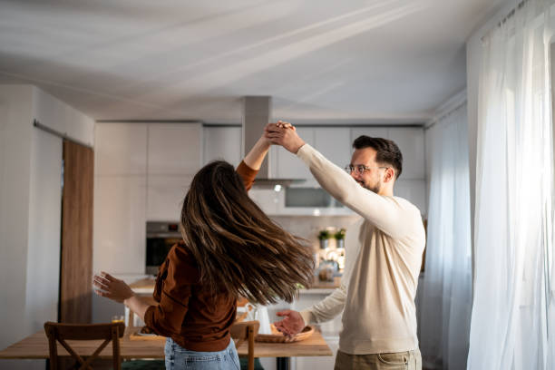istock Young couple dancing together in their modern kitchen 2205559637