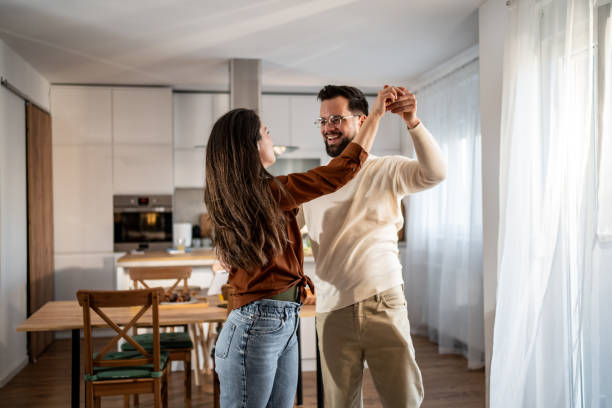 istock Happy couple dancing together in their modern kitchen 2205559661