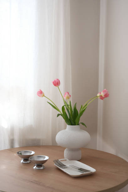 istock An elegantly arranged dining table adorned with radiant pink tulips, exquisite dinnerware, and delicate cutlery. 2205560791