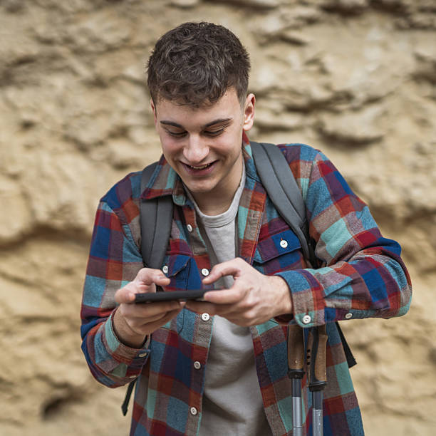 istock Young man hiker use mobile phone for fun or navigation on hiking trip 2205561877