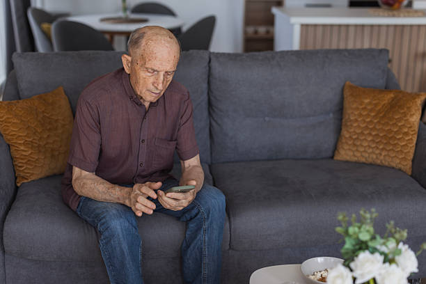 istock Senior man text messaging via smart phone 2205561934