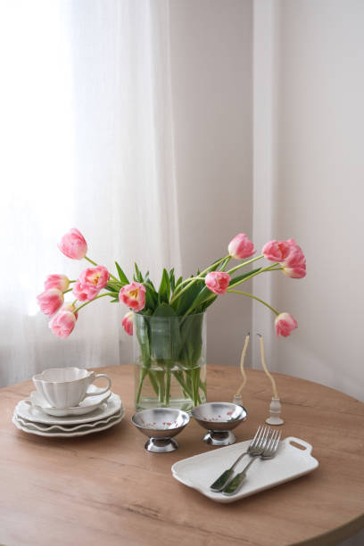 istock An elegantly arranged dining table adorned with radiant pink tulips, exquisite dinnerware, and delicate cutlery. 2205564328