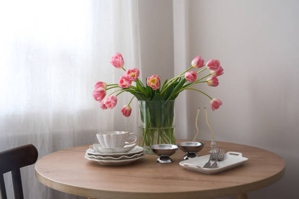 istock An elegantly arranged dining table adorned with radiant pink tulips, exquisite dinnerware, and delicate cutlery. 2205565644