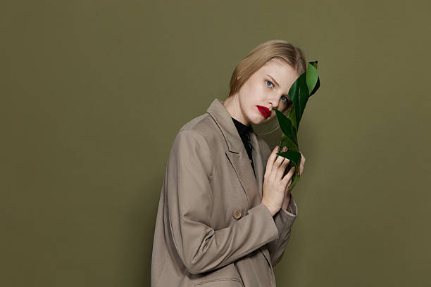 istock glamorous woman green palm leaf coat bright makeup studio model unaltered 2205567041