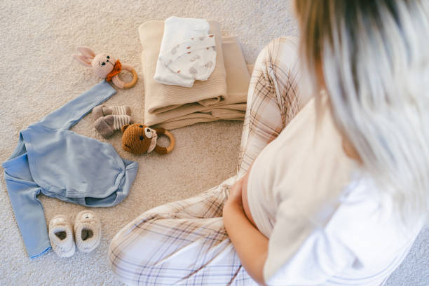 istock Young beautiful woman is packing her maternity bag. 2205571565