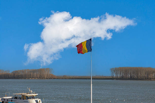 Rural landscape with national Romanian flag over Danube river banks in Galati, Romania.