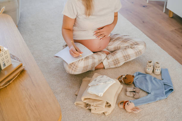istock Young beautiful woman is packing her maternity bag. 2205572866